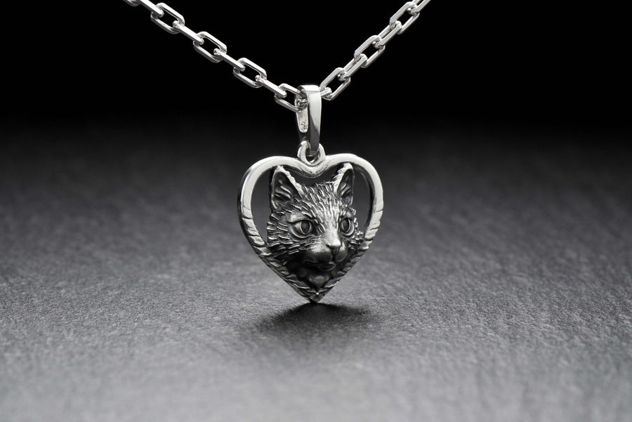 This beautiful and unique pendant features a lovely cat silhouette sitting in a heart-shaped frame. Handcrafted from high-quality sterling silver, this piece is perfect for cat lovers or anyone who appreciates intricate and detailed jewelry. __etsy:7357304418