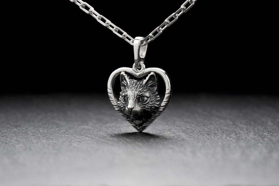 This beautiful and unique pendant features a lovely cat silhouette sitting in a heart-shaped frame. Handcrafted from high-quality sterling silver, this piece is perfect for cat lovers or anyone who appreciates intricate and detailed jewelry. __etsy:7357304418
