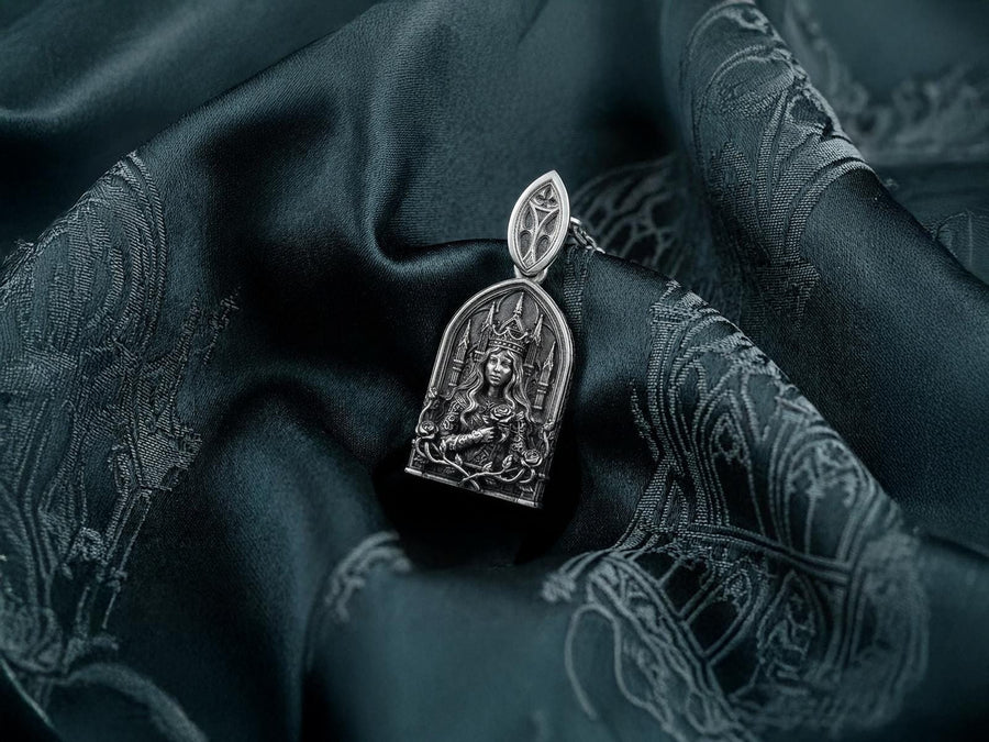 A close-up studio shot of a sterling silver pendant shaped like a Gothic cathedral arch. In the center, a sculpted queen or goddess with long flowing hair and a pointed crown holds a single rose to her chest. Behind her are intricately detailed cathedral spires. The bottom is framed by intertwined rose stems and blooms. The dark oxidation perfectly highlights the bright polished silver relief. __etsy:8051007659