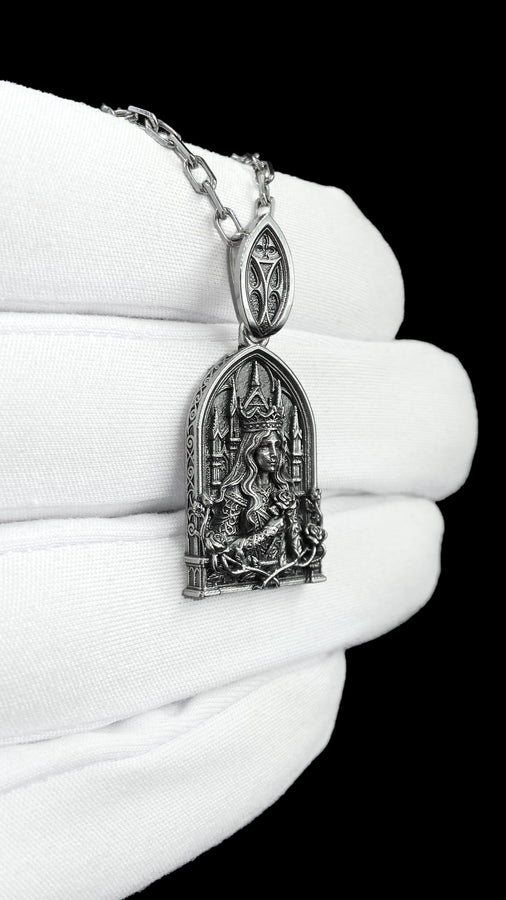 A close-up studio shot of a sterling silver pendant shaped like a Gothic cathedral arch. In the center, a sculpted queen or goddess with long flowing hair and a pointed crown holds a single rose to her chest. Behind her are intricately detailed cathedral spires. The bottom is framed by intertwined rose stems and blooms. The dark oxidation perfectly highlights the bright polished silver relief. __etsy:8051007659