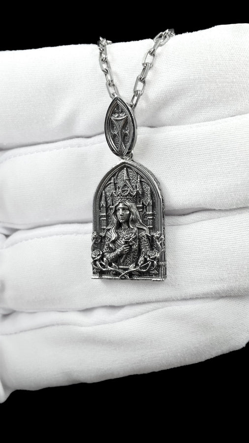 A close-up studio shot of a sterling silver pendant shaped like a Gothic cathedral arch. In the center, a sculpted queen or goddess with long flowing hair and a pointed crown holds a single rose to her chest. Behind her are intricately detailed cathedral spires. The bottom is framed by intertwined rose stems and blooms. The dark oxidation perfectly highlights the bright polished silver relief. __etsy:8051007659