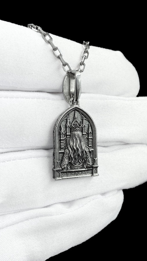 A close-up studio shot of a sterling silver pendant shaped like a Gothic cathedral arch. In the center, a sculpted queen or goddess with long flowing hair and a pointed crown holds a single rose to her chest. Behind her are intricately detailed cathedral spires. The bottom is framed by intertwined rose stems and blooms. The dark oxidation perfectly highlights the bright polished silver relief. __etsy:8051007659