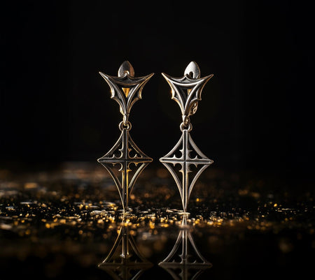 A detailed studio shot of a pair of sterling silver dangle earrings standing upright on a reflective black surface. The earrings have two sections: a top inverted triangle "shield" attached to the ear wire, and a bottom diamond-shaped charm. Both sections feature raised, sharp geometric lines forming a four-pointed star or cross pattern. The background metal is deeply oxidized black, contrasting with the polished silver ridges. __etsy:7448936166