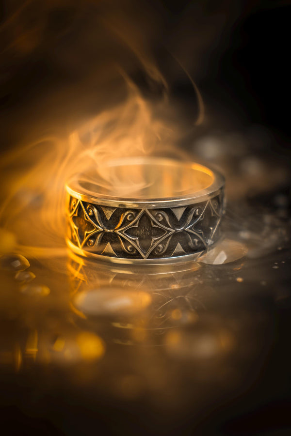A detailed macro shot of a sterling silver engagement ring. The focal point is a round, honey-colored gemstone (Citrine or Madeira Topaz) set flush into the band. The shank is decorated with a continuous relief pattern of spirals and circles, mimicking the decorative robes found in Gustav Klimt's "Golden Phase" paintings. The silver features an oxidized finish, creating a dark background that makes the polished spirals pop. (etsy image id: 7444385538)