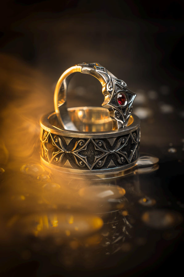 A detailed macro shot of a sterling silver engagement ring. The focal point is a round, honey-colored gemstone (Citrine or Madeira Topaz) set flush into the band. The shank is decorated with a continuous relief pattern of spirals and circles, mimicking the decorative robes found in Gustav Klimt's "Golden Phase" paintings. The silver features an oxidized finish, creating a dark background that makes the polished spirals pop. (etsy image id: 7444385538)