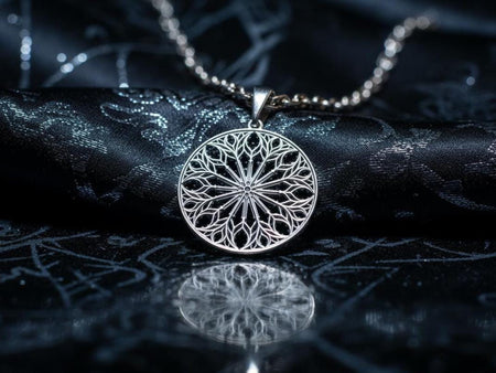 A high-contrast studio shot of a circular sterling silver pendant hanging from a chain. The design features a complex "Rayonnant" rose window motif with twelve distinct spokes radiating from a central hub. The delicate silver tracery forms a web of arches and circles. The raised metal is polished silver, contrasting with the matte black oxidation in the negative spaces, mimicking the depth of a stone window. __etsy:7448449526
