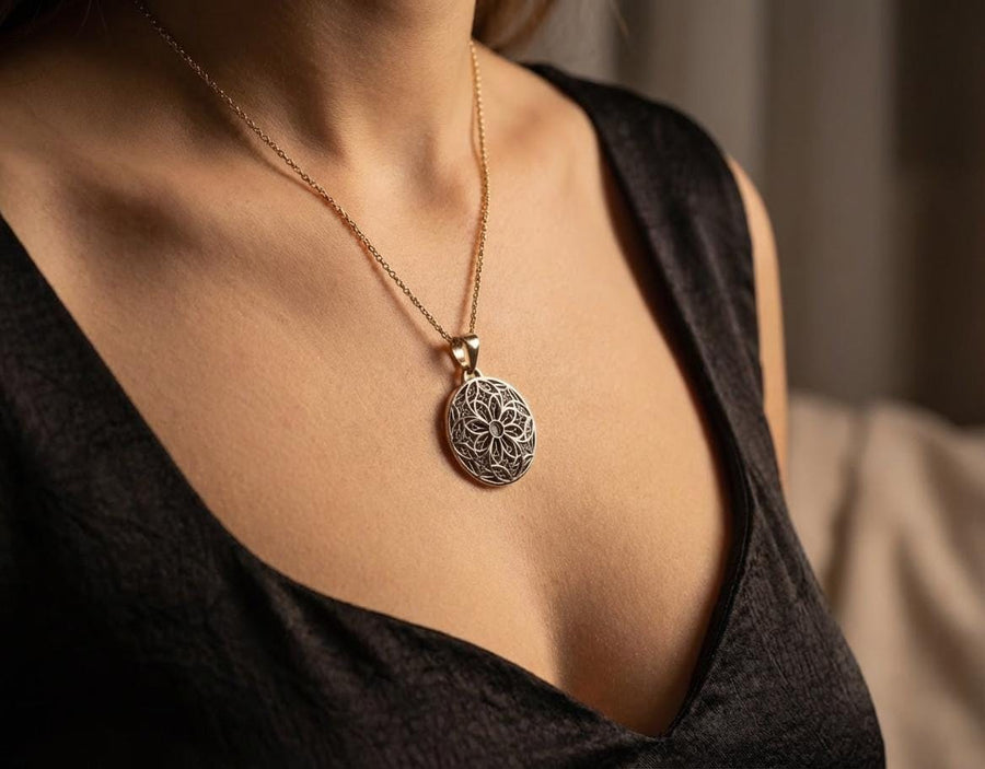 A detailed studio shot of a circular sterling silver pendant resting on a dark, textured slate background. The design is a geometric lattice based on the number four (quatrefoil). Four large teardrop-shaped arches meet in the center, subdivided by finer tracery lines. The raised silver network is polished, contrasting with the matte black oxidation in the negative spaces. __etsy:7446488454