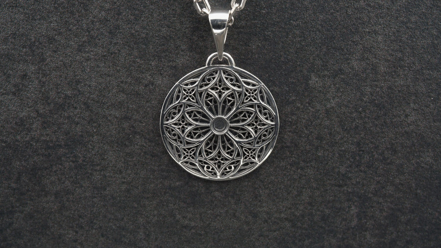 A detailed studio shot of a circular sterling silver pendant resting on a dark, textured slate background. The design is a geometric lattice based on the number four (quatrefoil). Four large teardrop-shaped arches meet in the center, subdivided by finer tracery lines. The raised silver network is polished, contrasting with the matte black oxidation in the negative spaces. __etsy:7446488454