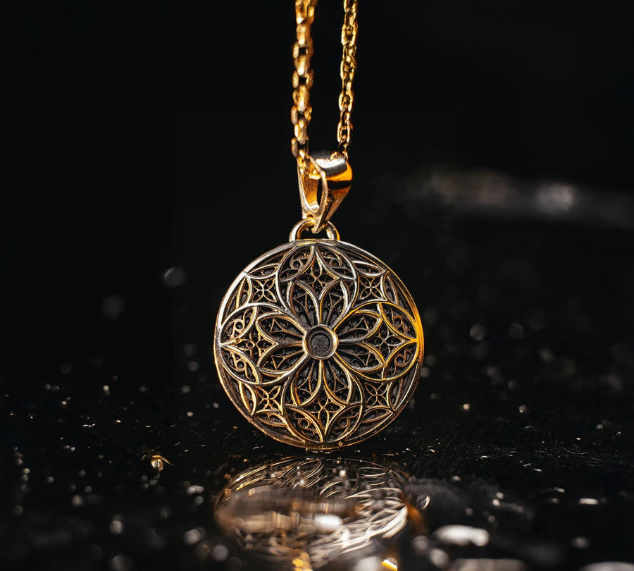 A detailed studio shot of a circular sterling silver pendant resting on a dark, textured slate background. The design is a geometric lattice based on the number four (quatrefoil). Four large teardrop-shaped arches meet in the center, subdivided by finer tracery lines. The raised silver network is polished, contrasting with the matte black oxidation in the negative spaces. __etsy:7446488454