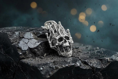 A close-up studio photograph of a highly detailed sterling silver pendant hanging from a sturdy chain against a black background. The striking design seamlessly merges the lower half of a fanged human skull with the upper structure of a Gothic cathedral. 