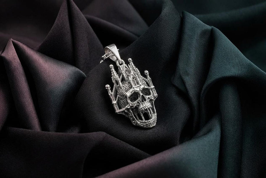 A close-up studio photograph of a highly detailed sterling silver pendant hanging from a sturdy chain against a black background. The striking design seamlessly merges the lower half of a fanged human skull with the upper structure of a Gothic cathedral. The architecture features soaring spires, pointed lancet arches, and intricate openwork tracery, with tiny skulls resting atop the outer pillars. __etsy:8027326873
