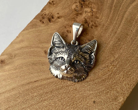 Whether you're a fan of these adorable and elusive felines or simply looking for a standout piece to complete your look, this silver sand cat pendant is sure to impress.