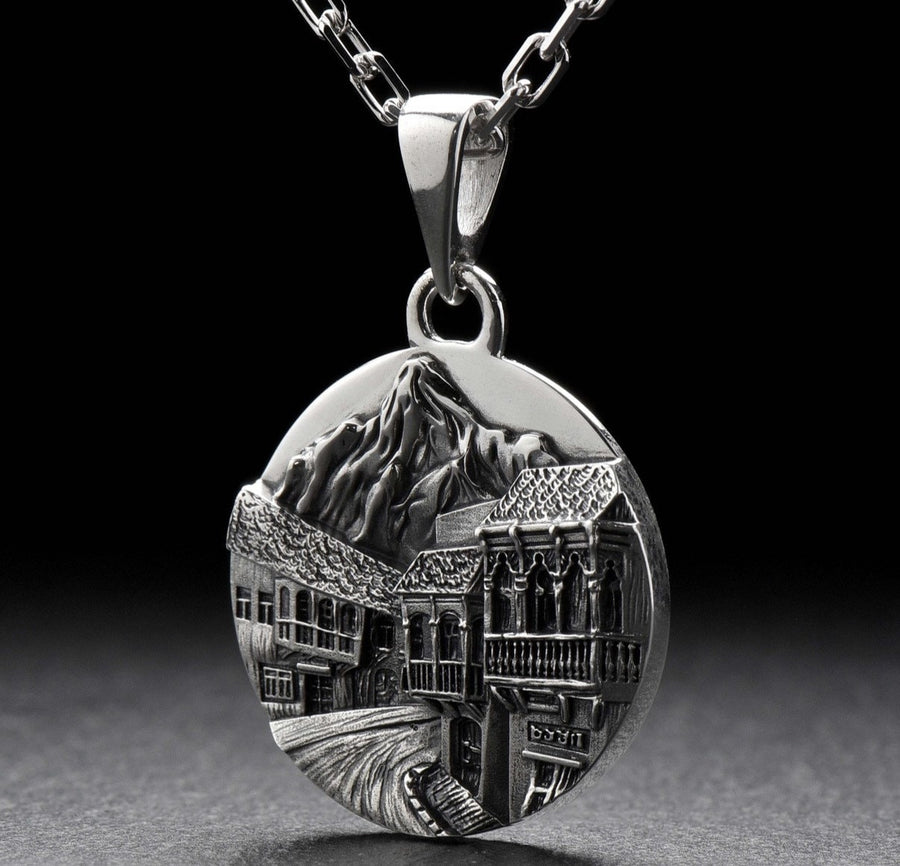 This beautiful pendant is the perfect souvenir to remember your trip to the beautiful city of Tbilisi. It features a detailed, hand-crafted design of the skyline of Tbilisi, Georgia.