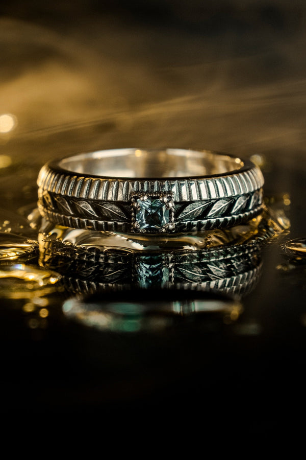 This sterling silver wedding band features intricate Victorian-inspired detailing, including finely engraved laurel leaves that wrap around the entire ring. The ribbed architectural edges create depth and texture, giving the piece an antique character reminiscent of handcrafted heirloom jewelry. Ideal for men or women who appreciate historic design and meaningful symbolism in their wedding band. __etsy:7473345891