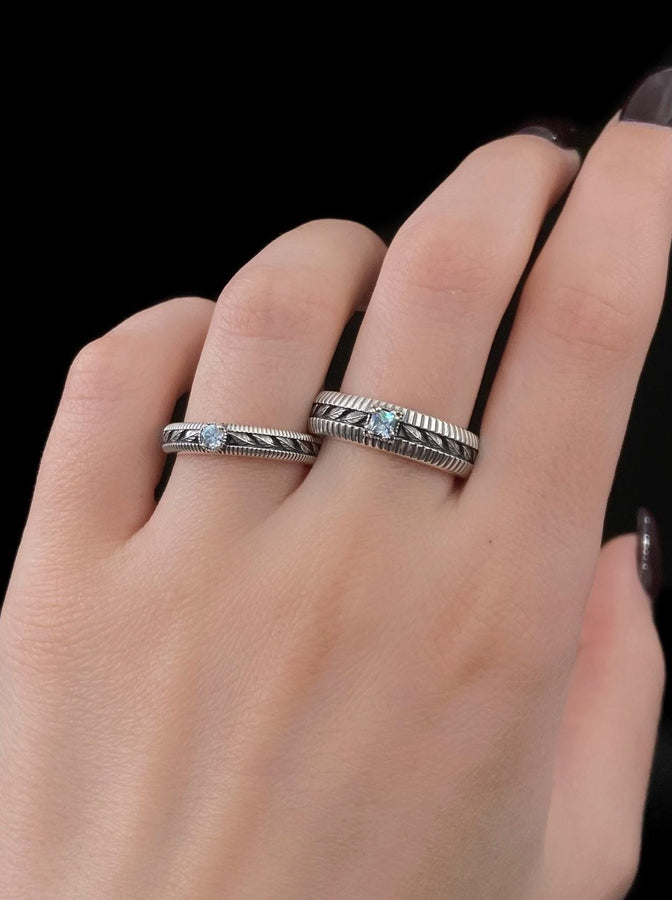 This sterling silver wedding band features intricate Victorian-inspired detailing, including finely engraved laurel leaves that wrap around the entire ring. The ribbed architectural edges create depth and texture, giving the piece an antique character reminiscent of handcrafted heirloom jewelry. Ideal for men or women who appreciate historic design and meaningful symbolism in their wedding band. __etsy:7473345891
