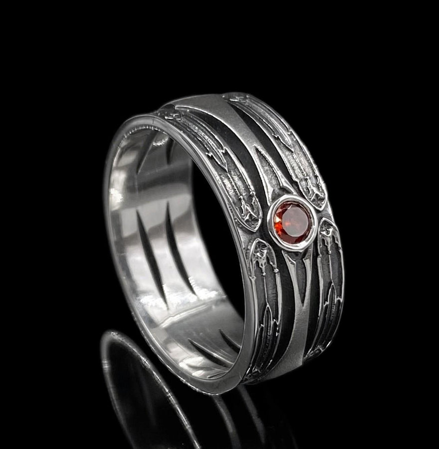 A high-contrast studio shot of a two-piece sterling silver ring set. The foreground features a wide band lying flat, set with a round clear gemstone. Flanking the stone are horizontal, grooved lines resembling arrows or spears. Standing behind it is a narrower engagement-style ring with a matching "lance-tip" shank leading to a central bezel-set white stone. The background is a textured, dark fabric. __etsy:7441122056