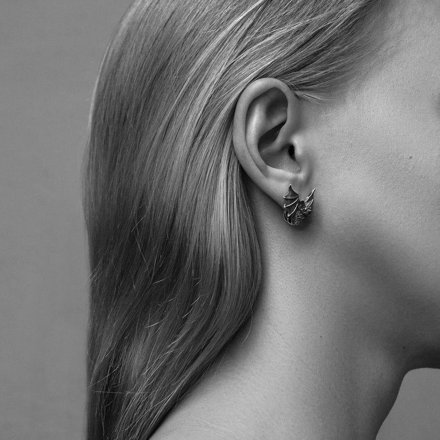 May include: A pair of silver earrings shaped like bats with detailed wings and faces. The hinged plug design allows them to sit securely and closely against the earlobe. Bathed in moody, low-key lighting, these gothic earrings evoke a mystical, nocturnal atmosphere perfect for a dark romance aesthetic. The beautifully detailed silver plug bat earrings capture the essence of vampirecore and whimsigoth fashion. (etsy image id: 5276595997)