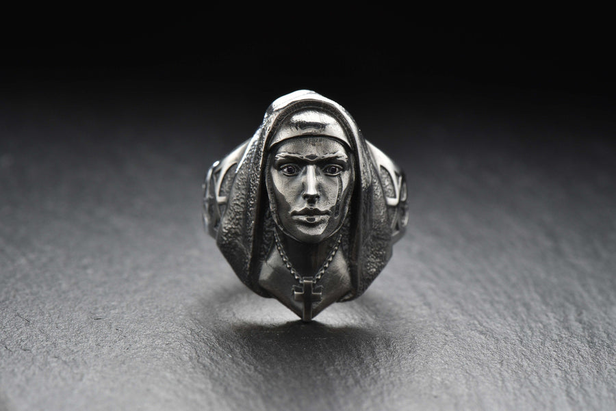 Crafted with meticulous attention to detail, this ring features a beautifully sculpted nun figure with a serene expression. The delicate design showcases the flowing robes and the distinct features that represent the dedicated life of a nun.