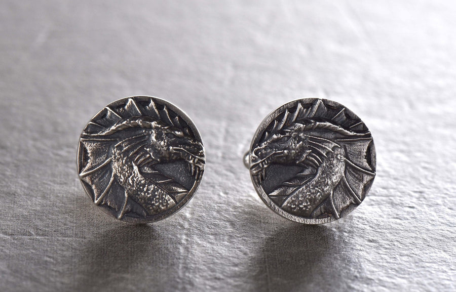 May include: A pair of silver cufflinks featuring a detailed dragon head design. (etsy image id: 7689558200)