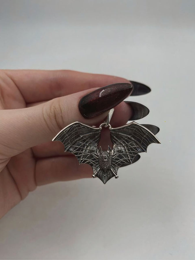 Featuring a detailed bat with outstretched wings, our unique design is sure to stand out. Don't let the darkness keep you down—power up your style with a silver bat pendant today! (etsy image id: 6086867201)