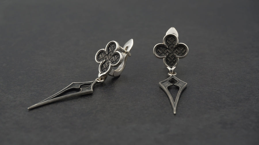 With their timeless beauty and one-of-a-kind design, these earrings are a must-have accessory for anyone who wants to stand out from the crowd. Don't miss this opportunity to own a piece of gothic elegance, order now! The image highlights the contrast between the two sections. The stud features a dense, "micro-relief" pattern that looks like chainmail or textile. The drop is smooth and linear, providing a visual break. (etsy image id: 7090850125)