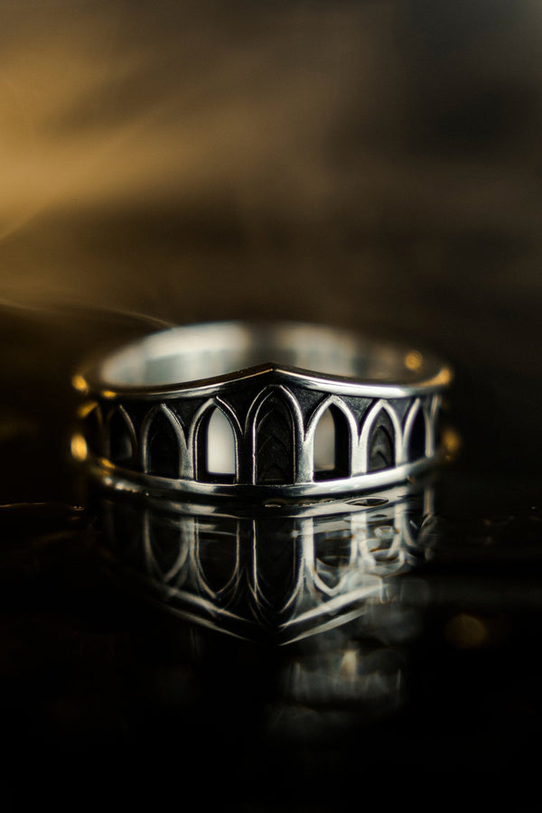 A professional studio photograph of a matching two-piece sterling silver wedding ring set. Both rings feature a prominent, raised Greek-style cross motif in the center, which holds a round, bezel-set white crystal. The interior of the cross arms has a fine, cross-hatched grid texture. Along the sides of the high-polished silver bands are recessed, four-lobed quatrefoil shapes. The rings are presented against a pitch-black background, making the p __etsy:8051335185