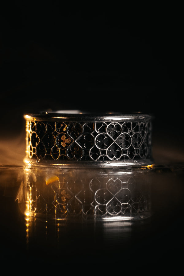 This view focuses on the tactile quality of the 925 sterling silver. The raised lattice framework is smooth and rounded, ensuring it won't snag on clothing, while the black background has a stippled, grainy texture that absorbs light. The image captures the "chiaroscuro" effect of the metalwork—the interplay of light silver and dark shadow—which gives the ring a rugged, masculine feel suitable for daily wear. (etsy image id: 6052185804)