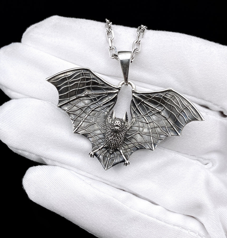 Featuring a detailed bat with outstretched wings, our unique design is sure to stand out. Don't let the darkness keep you down—power up your style with a silver bat pendant today! (etsy image id: 6086867201)