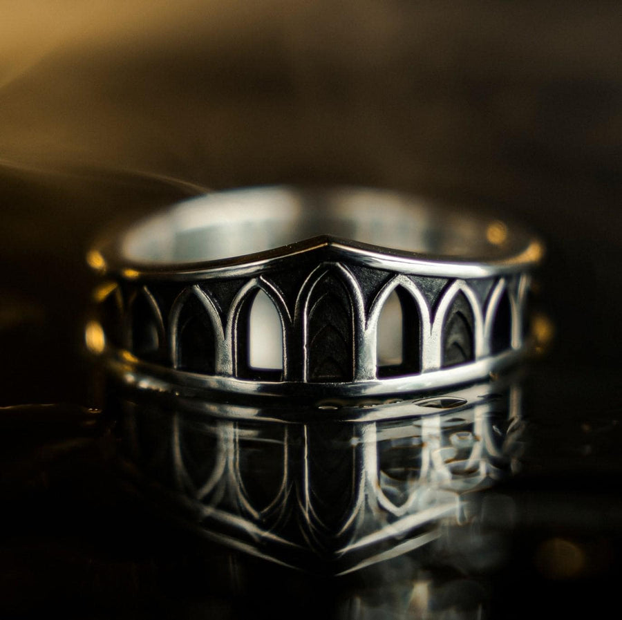 A professional studio photograph of a matching two-piece sterling silver wedding ring set. Both rings feature a prominent, raised Greek-style cross motif in the center, which holds a round, bezel-set white crystal. The interior of the cross arms has a fine, cross-hatched grid texture. Along the sides of the high-polished silver bands are recessed, four-lobed quatrefoil shapes. The rings are presented against a pitch-black background, making the p __etsy:8051335185