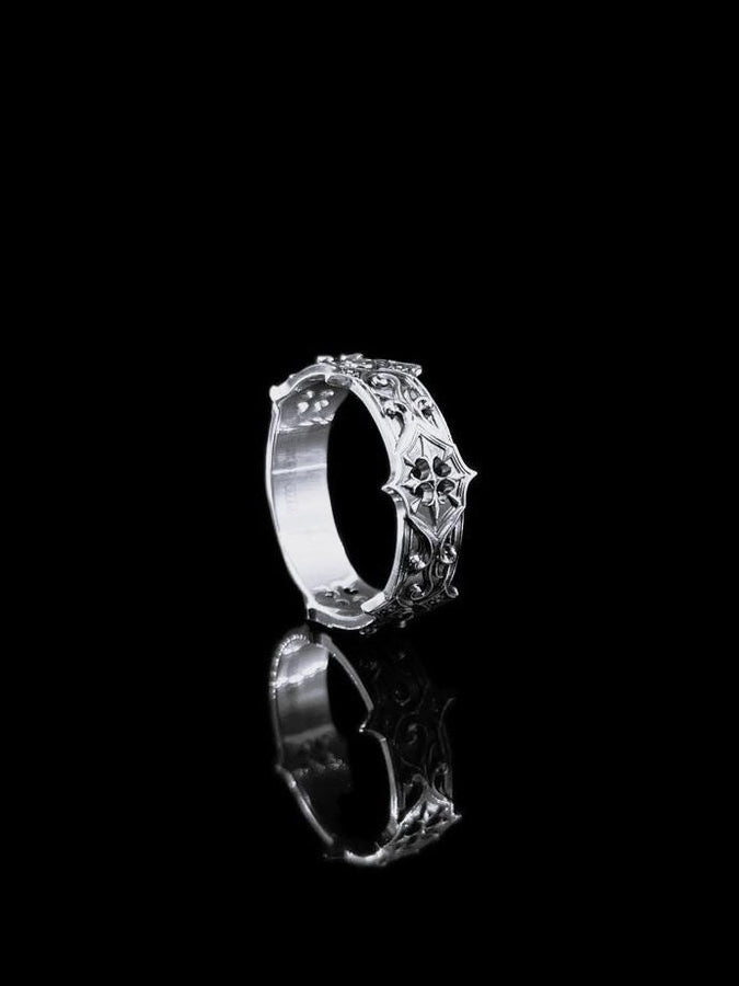 Handmade sterling silver band with an intricate gothic crown motif in the center, framed by swirling ornamental engravings. The deep relief and antique darkened finish evoke historic cathedral carvings. Ideal for customers seeking dark romantic jewelry, gothic accessories, medieval wedding rings, and meaningful silver bands with symbolic architecture-inspired designs. (etsy image id: 7423455351)