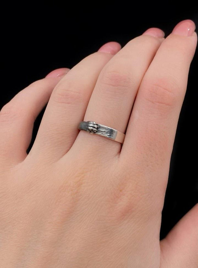 A pair of gothic sterling silver wedding rings featuring sculpted claw details that wrap organically around each band. The dramatic design blends polished metal with textured claw surfaces, creating a symbolic representation of unity and strength. Ideal for alternative couples who appreciate bold artisan jewelry with dark, meaningful aesthetics and handcrafted quality suitable for weddings or promise rings.