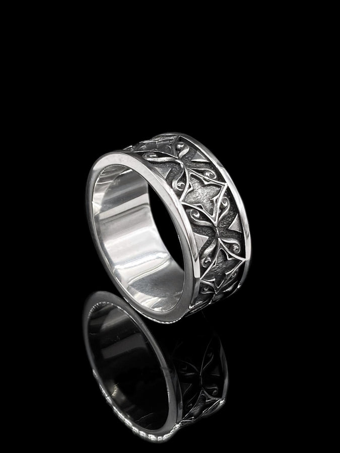 A detailed macro shot of a sterling silver engagement ring. The focal point is a round, honey-colored gemstone (Citrine or Madeira Topaz) set flush into the band. The shank is decorated with a continuous relief pattern of spirals and circles, mimicking the decorative robes found in Gustav Klimt's "Golden Phase" paintings. The silver features an oxidized finish, creating a dark background that makes the polished spirals pop. (etsy image id: 7444385538)
