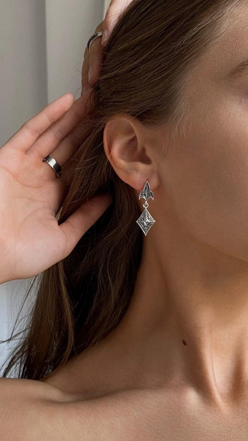 Embrace the dark allure of Gothic fashion with our Sterling Silver Gothic Earrings. Crafted with meticulous attention to detail, these earrings exude sophistication and mystique, perfect for those who appreciate the darker side of elegance. The mood is regal and sophisticated, appealing to fans of "Royal Core" aesthetics, historical dramas, or Victorian fashion. (etsy image id: 6150688147)