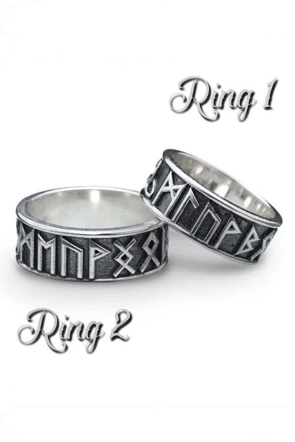 A clean studio shot of two matching sterling silver rings. The bands feature the 24 characters of the Elder Futhark runic alphabet wrapping around the exterior. The runes are polished silver, standing out sharply against a rough, blackened background texture. The rims are smooth and polished, framing the ancient script.