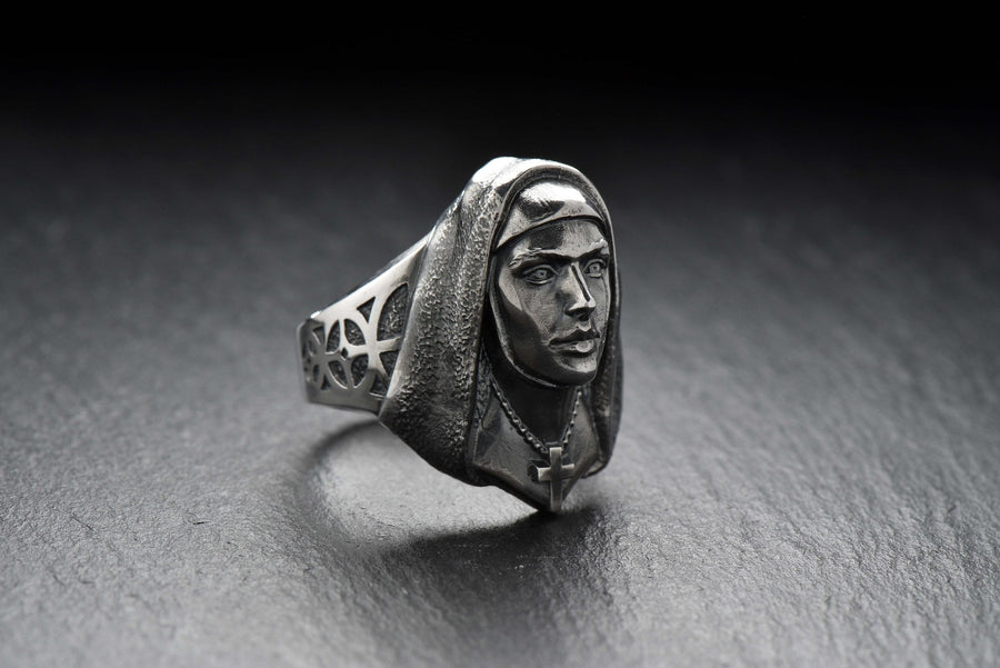 Crafted with meticulous attention to detail, this ring features a beautifully sculpted nun figure with a serene expression. The delicate design showcases the flowing robes and the distinct features that represent the dedicated life of a nun.
