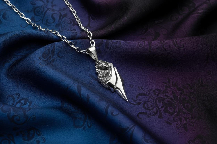 A detailed close-up studio shot of a sterling silver pendant shaped like two flying foxes or fruit bats. The bats are intimately huddled together, wrapped within the smooth, sweeping folds of their leathery wings. The metal is highly textured to show the fine details of their fur and faces. The silver is heavily oxidized in the recesses, creating a striking contrast against the polished highlights of the wings. (etsy image id: 5592925539)