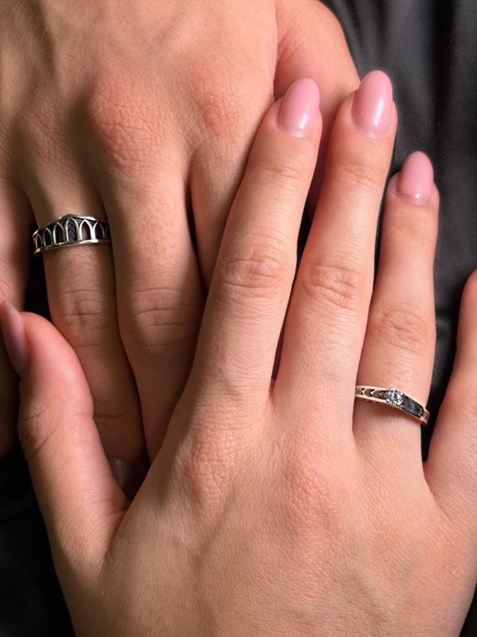 A professional studio photograph of a matching two-piece sterling silver wedding ring set. Both rings feature a prominent, raised Greek-style cross motif in the center, which holds a round, bezel-set white crystal. The interior of the cross arms has a fine, cross-hatched grid texture. Along the sides of the high-polished silver bands are recessed, four-lobed quatrefoil shapes. The rings are presented against a pitch-black background, making the p __etsy:8051335185