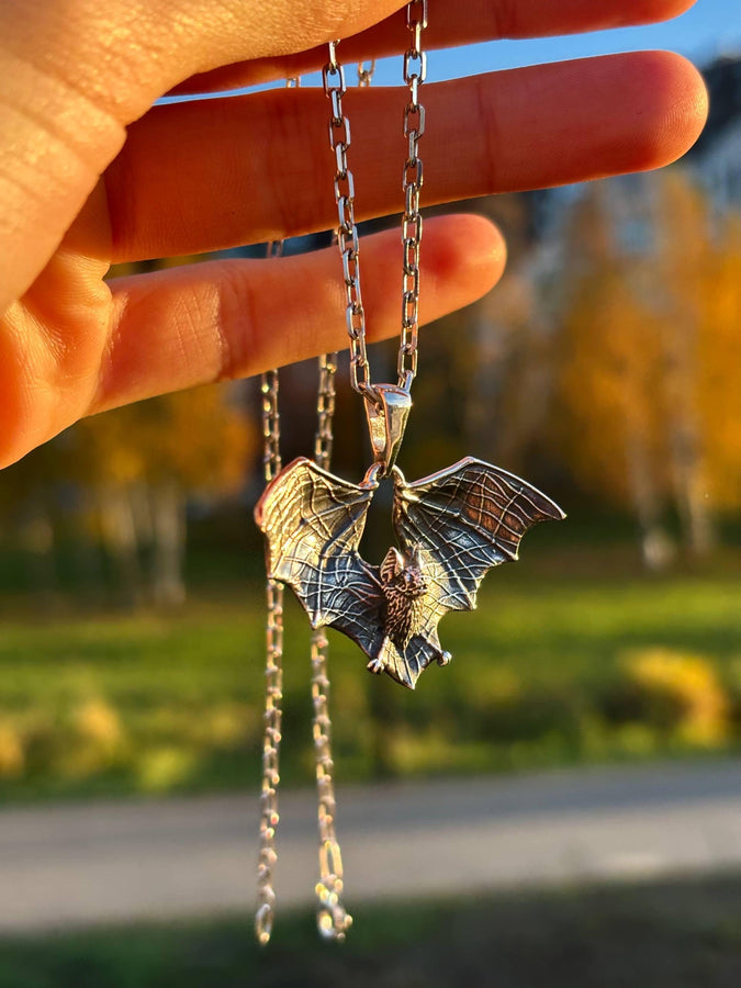 Featuring a detailed bat with outstretched wings, our unique design is sure to stand out. Don't let the darkness keep you down—power up your style with a silver bat pendant today! (etsy image id: 6086867201)