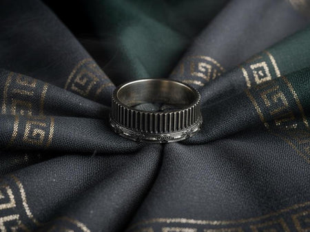 This sterling silver wedding band features a detailed Ionic column design with vertical fluting wrapped around the entire ring. Sculpted scrollwork along the top edge adds architectural character inspired by ancient Greek temples. The reflective silver surface highlights the balance of Art Deco lines and classical motifs, creating a bold and meaningful wedding band for lovers of history and craftsmanship. (etsy image id: 7417916460)