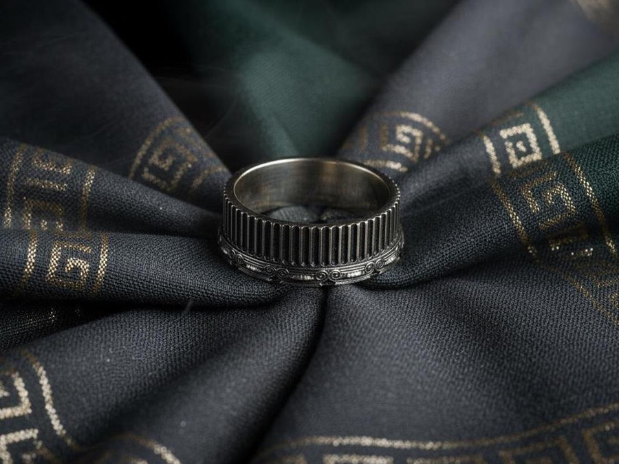 A polished sterling silver wedding band inspired by historical Greek architecture, featuring full-length vertical column lines and detailed Ionic scrollwork. The ring’s reflective interior contrasts with the textured exterior, emphasizing craftsmanship and depth. This Art Deco–style temple band is ideal for those who love structural jewelry rooted in ancient culture and timeless design. (etsy image id: 7193919287)