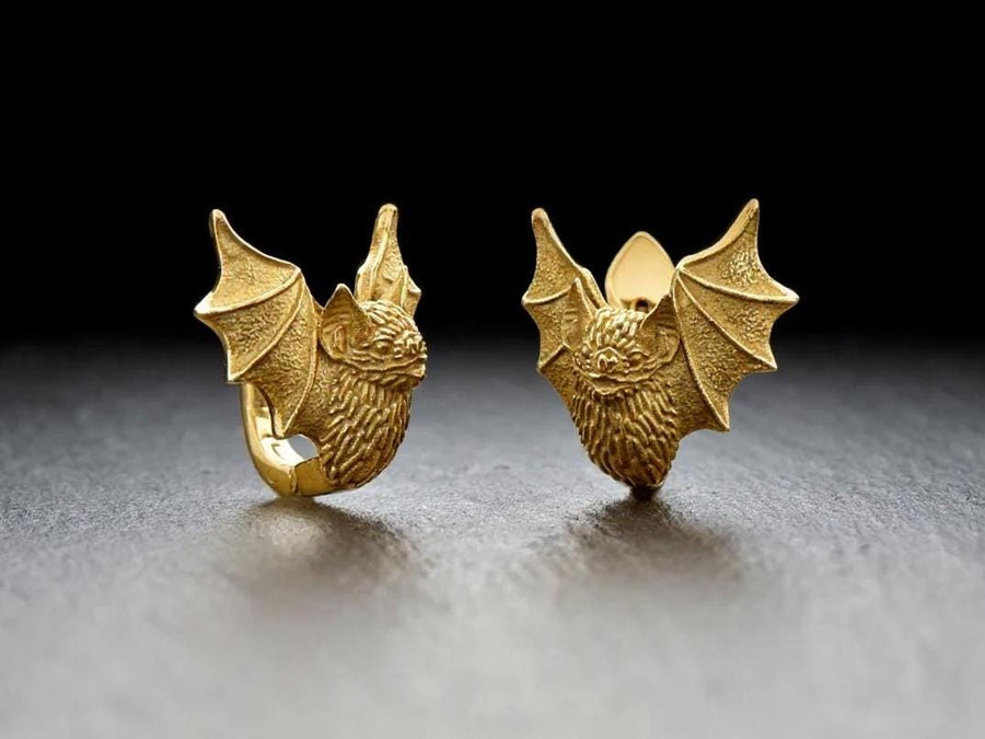 May include: A pair of silver earrings shaped like bats with detailed wings and faces. The hinged plug design allows them to sit securely and closely against the earlobe. Bathed in moody, low-key lighting, these gothic earrings evoke a mystical, nocturnal atmosphere perfect for a dark romance aesthetic. The beautifully detailed silver plug bat earrings capture the essence of vampirecore and whimsigoth fashion. (etsy image id: 5276595997)