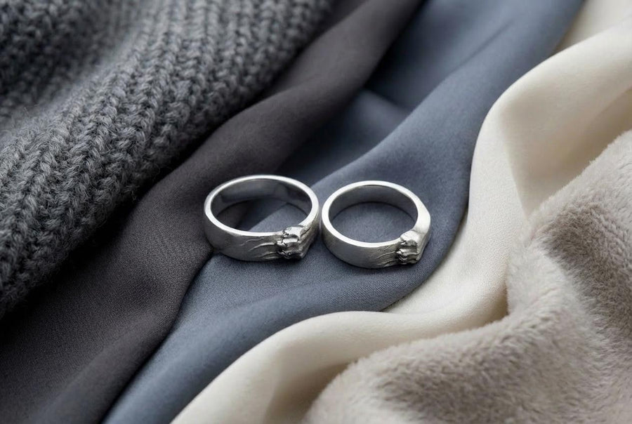 A pair of gothic sterling silver wedding rings featuring sculpted claw details that wrap organically around each band. The dramatic design blends polished metal with textured claw surfaces, creating a symbolic representation of unity and strength. Ideal for alternative couples who appreciate bold artisan jewelry with dark, meaningful aesthetics and handcrafted quality suitable for weddings or promise rings.