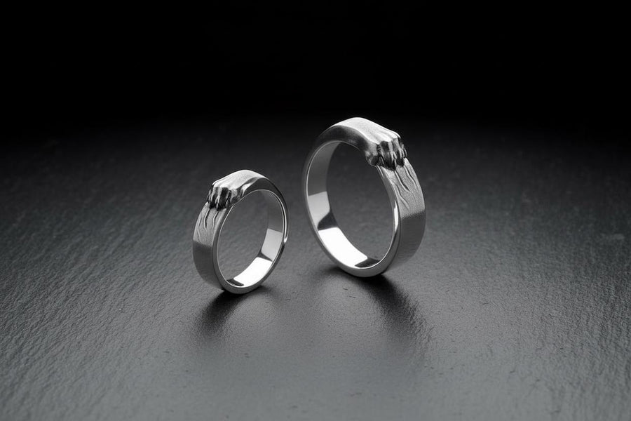 A pair of gothic sterling silver wedding rings featuring sculpted claw details that wrap organically around each band. The dramatic design blends polished metal with textured claw surfaces, creating a symbolic representation of unity and strength. Ideal for alternative couples who appreciate bold artisan jewelry with dark, meaningful aesthetics and handcrafted quality suitable for weddings or promise rings.