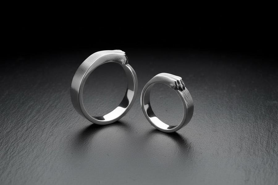 A pair of gothic sterling silver wedding rings featuring sculpted claw details that wrap organically around each band. The dramatic design blends polished metal with textured claw surfaces, creating a symbolic representation of unity and strength. Ideal for alternative couples who appreciate bold artisan jewelry with dark, meaningful aesthetics and handcrafted quality suitable for weddings or promise rings.