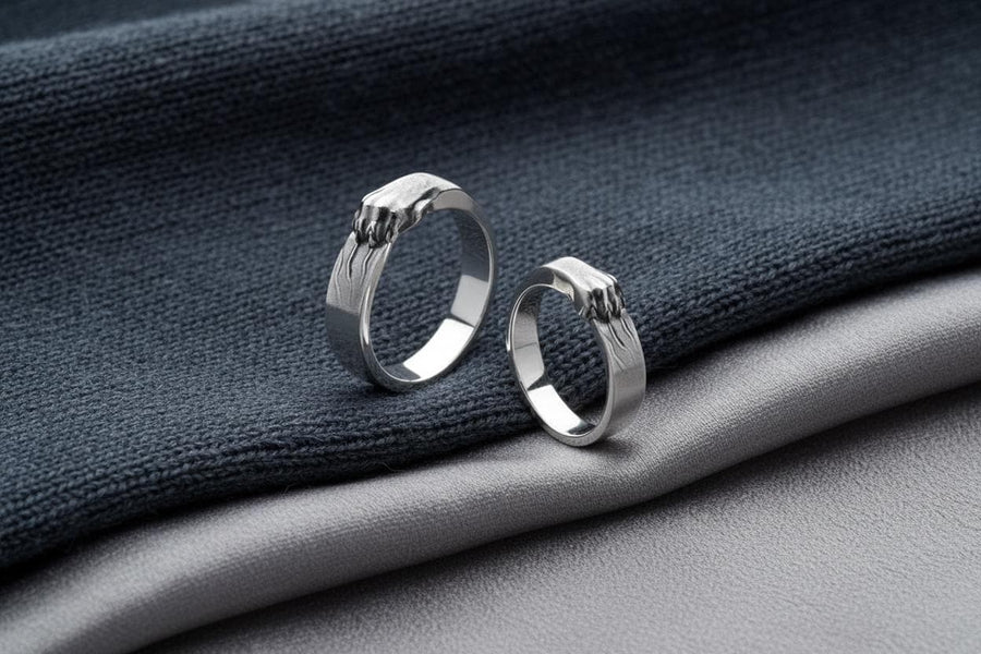 A pair of gothic sterling silver wedding rings featuring sculpted claw details that wrap organically around each band. The dramatic design blends polished metal with textured claw surfaces, creating a symbolic representation of unity and strength. Ideal for alternative couples who appreciate bold artisan jewelry with dark, meaningful aesthetics and handcrafted quality suitable for weddings or promise rings.