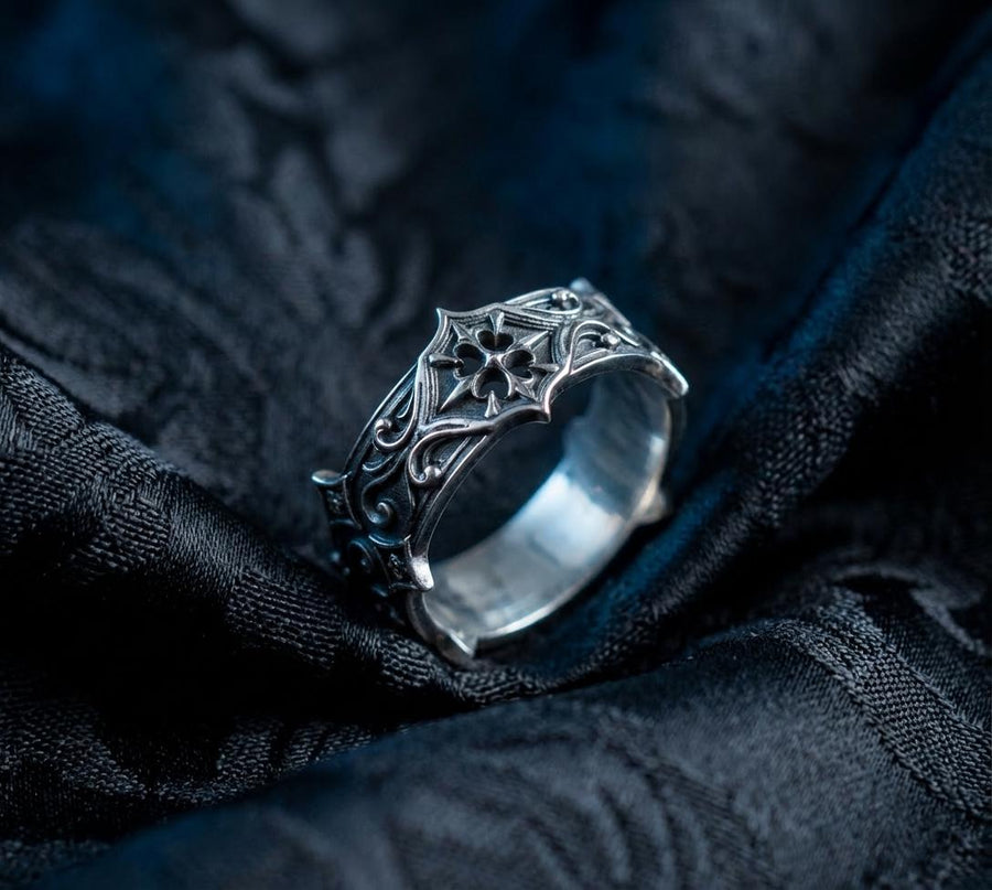 Handmade sterling silver band with an intricate gothic crown motif in the center, framed by swirling ornamental engravings. The deep relief and antique darkened finish evoke historic cathedral carvings. Ideal for customers seeking dark romantic jewelry, gothic accessories, medieval wedding rings, and meaningful silver bands with symbolic architecture-inspired designs. (etsy image id: 7423455351)