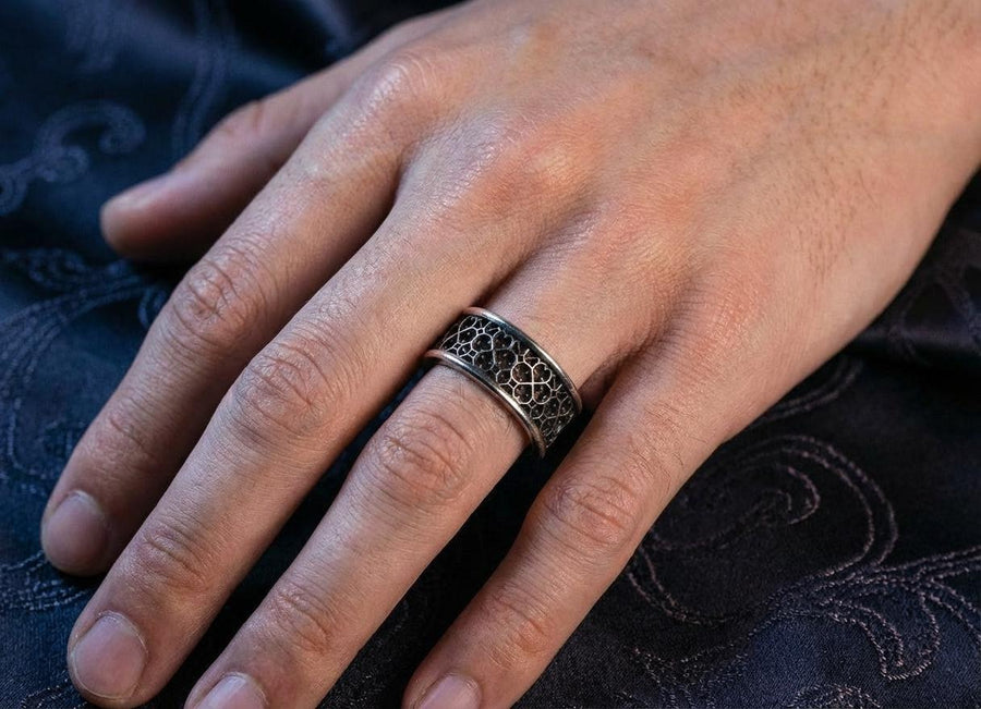 This view focuses on the tactile quality of the 925 sterling silver. The raised lattice framework is smooth and rounded, ensuring it won't snag on clothing, while the black background has a stippled, grainy texture that absorbs light. The image captures the "chiaroscuro" effect of the metalwork—the interplay of light silver and dark shadow—which gives the ring a rugged, masculine feel suitable for daily wear. (etsy image id: 6052185804)