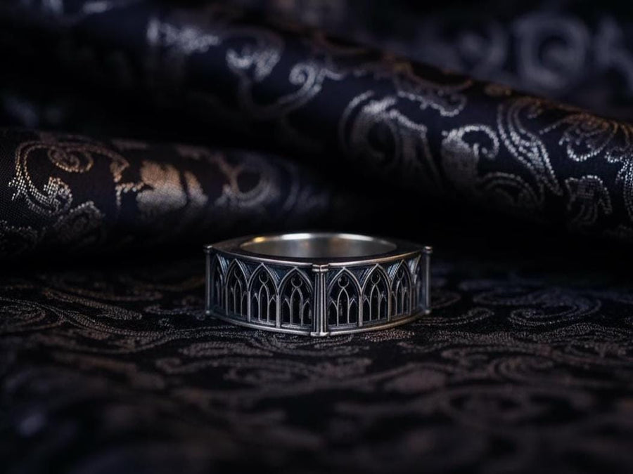 Defend your realm with this architectural fortress ring. Distinctive for its soft-square outer profile, this sterling silver band features a continuous cloister of Gothic arches anchored by robust corner buttresses. The geometric design mimics the stone ramparts of a medieval castle. Heavily oxidized to reveal the depth of the masonry, it is a symbol of unshakeable strength and structure. A bold statement for the guardian of history. (etsy image id: 7450412634)