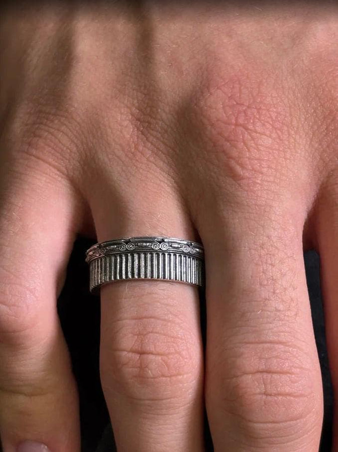A polished sterling silver wedding band inspired by historical Greek architecture, featuring full-length vertical column lines and detailed Ionic scrollwork. The ring’s reflective interior contrasts with the textured exterior, emphasizing craftsmanship and depth. This Art Deco–style temple band is ideal for those who love structural jewelry rooted in ancient culture and timeless design. (etsy image id: 7193919287)