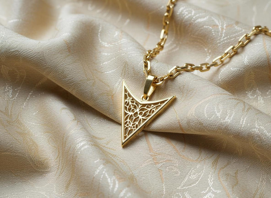 A detailed studio shot of an inverted triangle-shaped pendant hanging from a sturdy chain. The design features a "V" shape frame filled with complex, organic filigree. The inner pattern resembles branching roots, veins, or the "Flamboyant" style of late Gothic window tracery. The raised silver lines are polished bright, contrasting with the matte black oxidation in the negative spaces. (etsy image id: 7496362357)